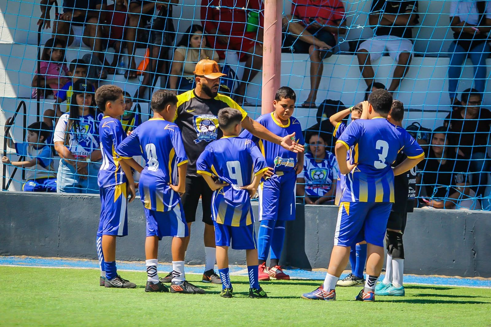 Time reunido recebendo orientação tática durante o treino